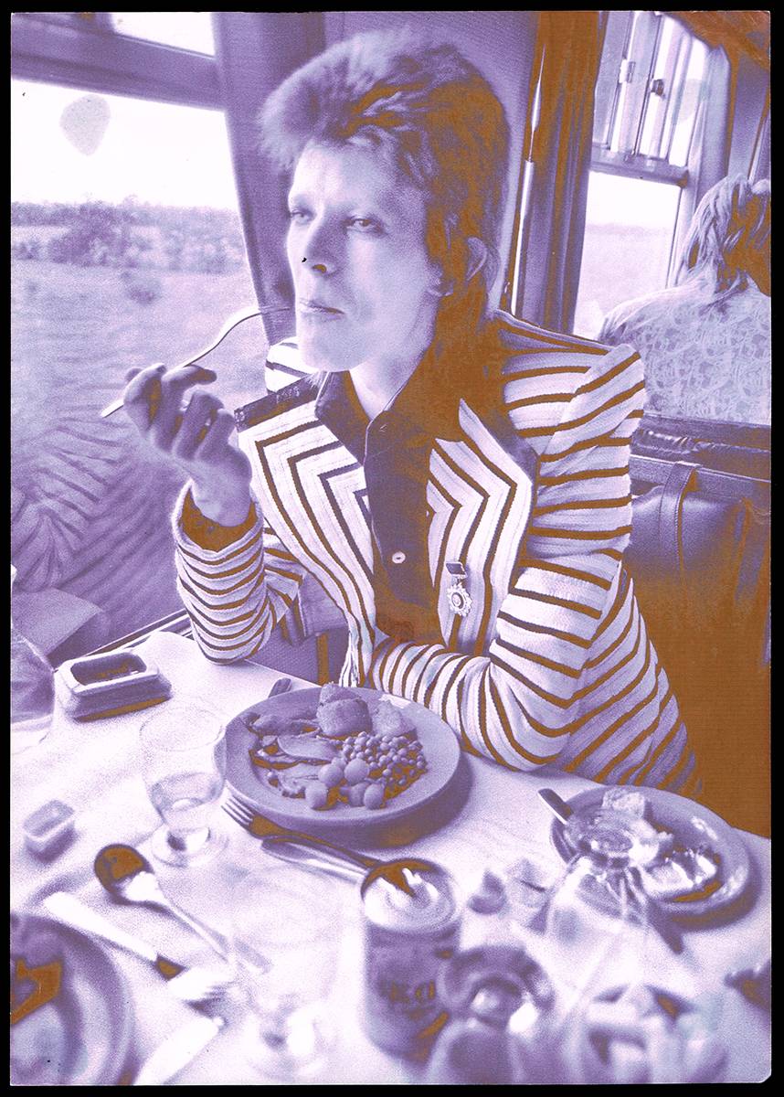 DAVID BOWIE AT LUNCH ON TRAIN TO ABERDEEN, 1973 by Mick Rock (1948-2021) at Whyte's Auctions
